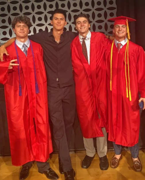 Cortland with three friends in graduation gowns