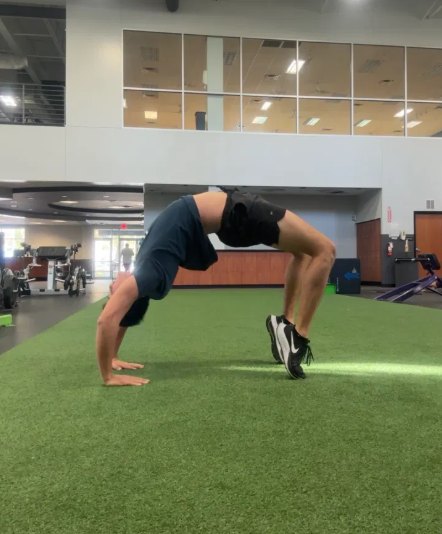 Cortland holding a backbend on gym turf